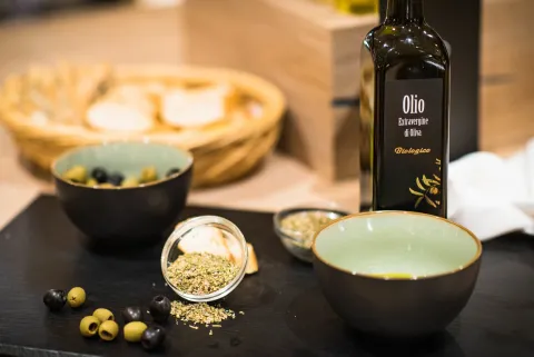 Bio-Olivenöl mit frischen grünen und schwarzen Oliven, Brot und Oregano