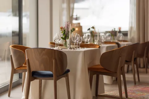 Festlich gedeckte Tische im Restaurant mit Weingläsern, Kerzenständer und Blumenschmuck