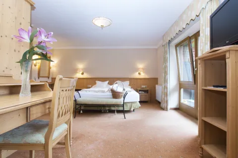 Hotelzimmer mit Doppelbett, Kofferablage, Balkon und Schreibtisch aus Holz