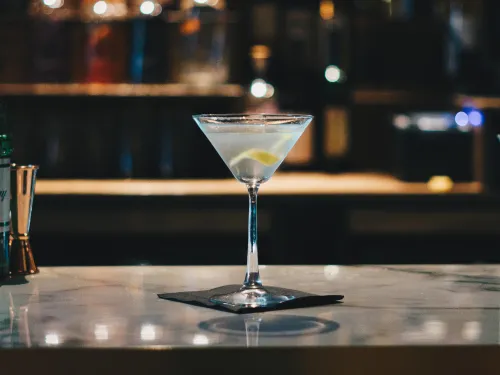 Martini-Cocktail mit Zitronenschale auf einem Bartresen