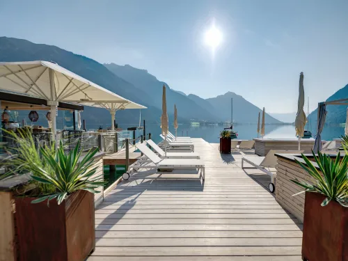 Badesteg am Achensee im Sommer mit Sonnenliegen, Schirmen und Bar