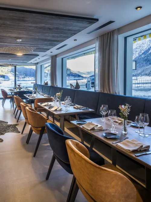 Restaurant mit gedeckten Tischen und moderner Bar mit Aussicht auf den Achensee im Winter